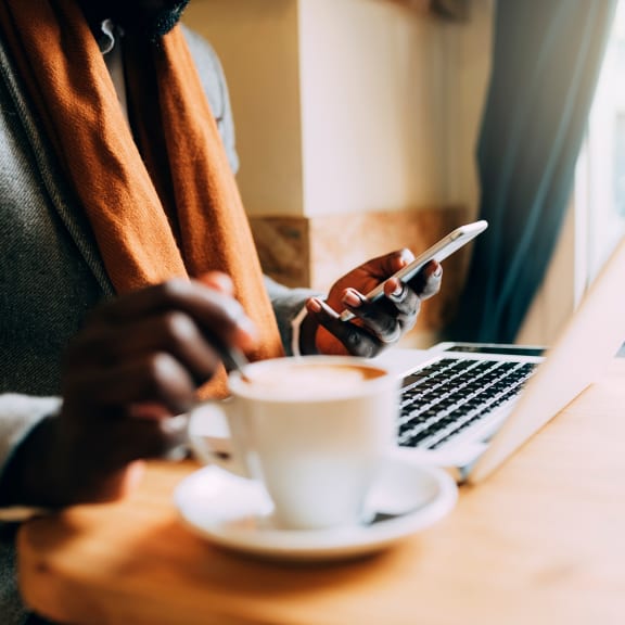 a person sitting at a table with a cup of coffee at Fiore Townhomes, Venice