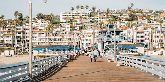A beautiful beach scene with palm trees and flowers in the foreground.