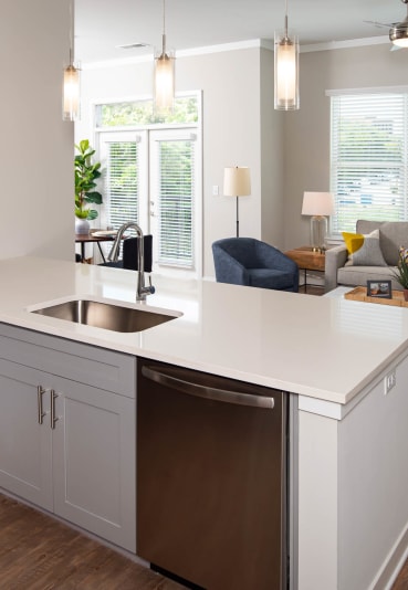 a kitchen with an island and a living room with a couch at One Riverside Apartments, Tennessee, 37403
