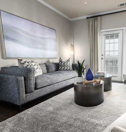 a living room with couches and chairs and a large picture on the wall