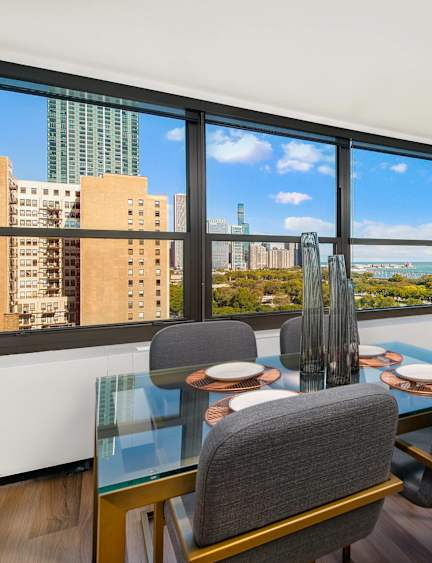 Dining area with glass table and lake views at Eleven Thirty Apartments, Chicago, 60605