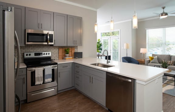 a kitchen with stainless steel appliances and a white counter top at One Riverside Apartments, Chattanooga