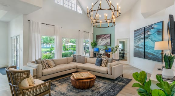 a living room with a large couch and a chandelier at The Villas at Ibis Landing, Parkland, FL