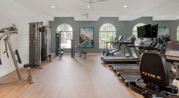 the gym has treadmills and other exercise equipment and windows at The Villas at Ibis Landing, Parkland, 33067