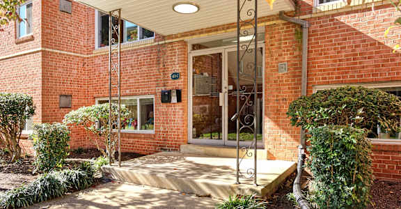 A red brick house with a white roof and a glass door.