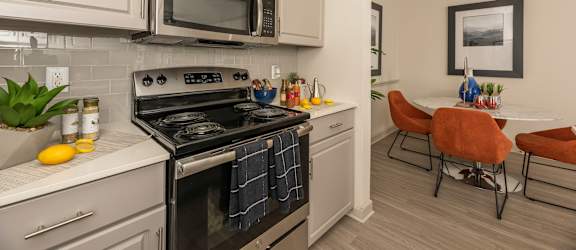 Kitchen with a black stove at Woodbridge Villas Apartments, Sachse, 75048