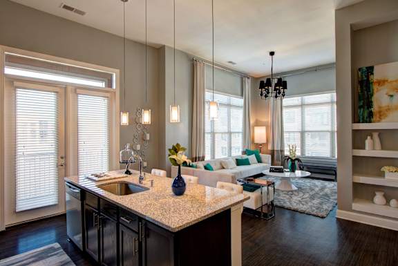 A kitchen with a large island and a dining area in the background.
