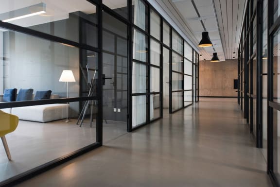 a glass walled room with a couch and a table