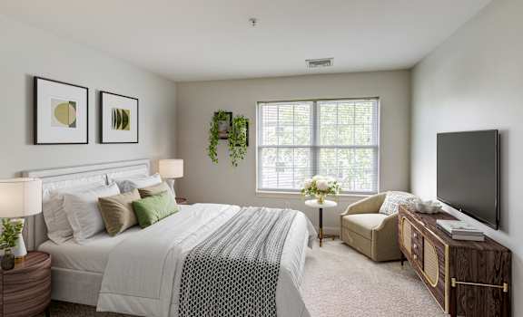 a bedroom with a bed and a chair and a television