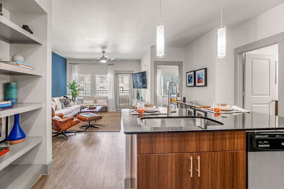 A modern kitchen with a dining area and a living room.