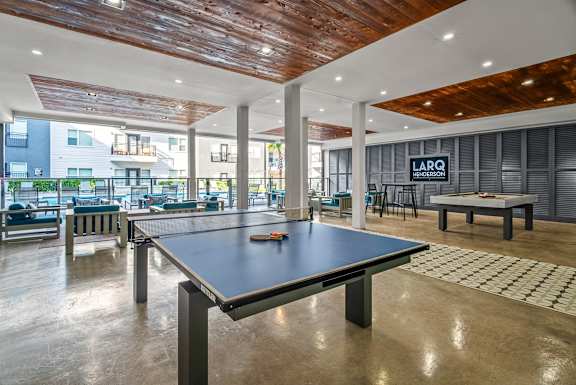 A black table is in the middle of a room with a wooden ceiling.