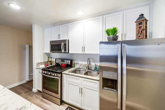 A kitchen with a stove, oven, refrigerator, and microwave.