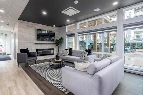 A modern living room with a grey sofa and a fireplace.