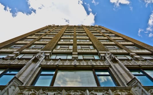 an upward view of a tall building with a cloudy sky at Garment Lofts, Los Angeles, CA 90014