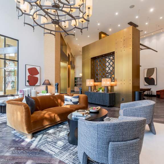 A living room with a brown couch, grey armchair, and a coffee table.