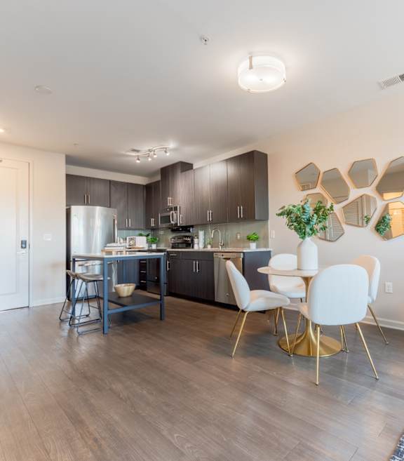 a kitchen with dark cabinets and stainless steel appliances at Heights at Glen Mills, Glen Mills, PA