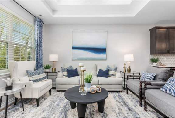 A living room with a large painting, a white sofa, and a coffee table.