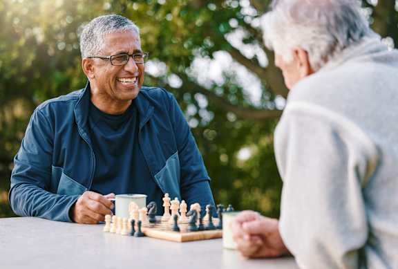two older men playing chess at a table at The Carillon, Greensboro, NC
