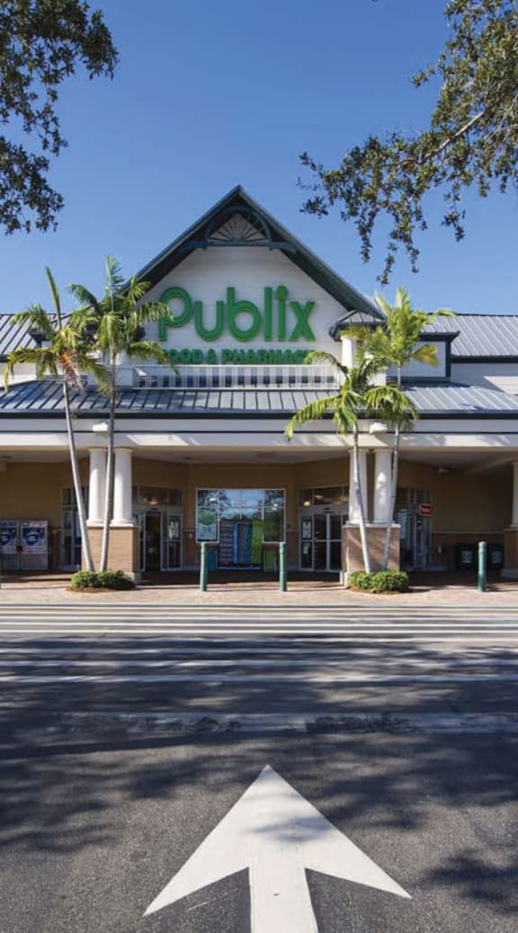 A building with a sign that says "Publix" is surrounded by trees.