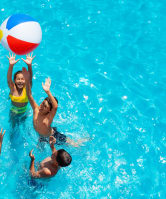 children playing in a pool with a beach ball
