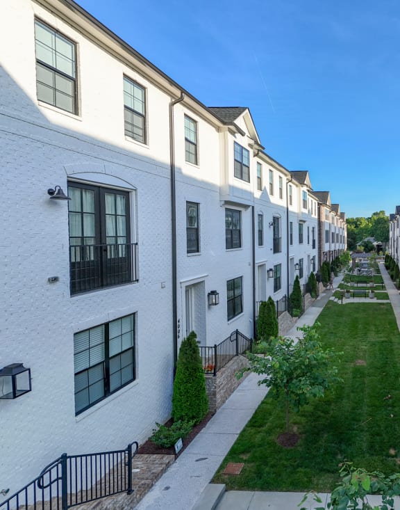 an alleyway between rows of white and brick apartment buildings