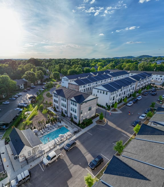 a aerial view of a hotel with a swimming pool and buildings