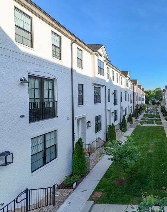 an alleyway between rows of white and brick apartment buildings
