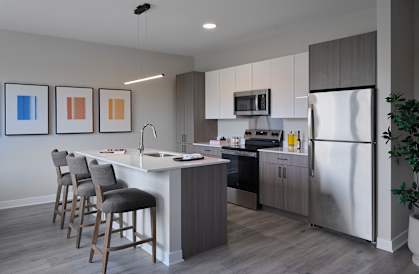 A modern kitchen with a white island and stainless steel appliances.