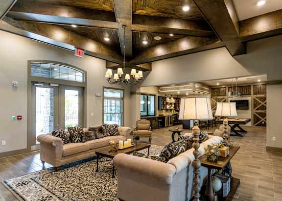 A large, well-lit living room with a couch, coffee table, and a rug.