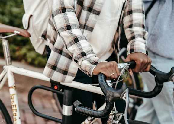A person in a plaid shirt is riding a bicycle.
