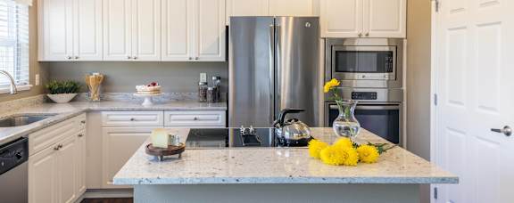A modern kitchen with wooden cabinets and stainless steel appliances.
