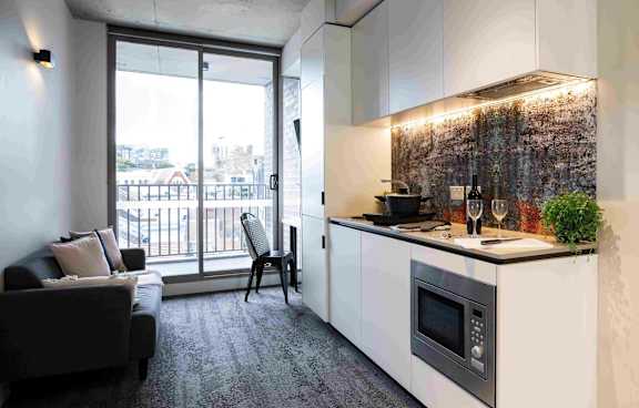 a living room with a green couch and a balcony