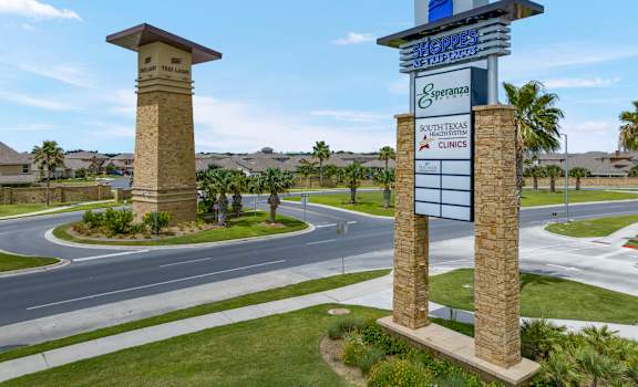 A sign for Sheppard's South Texas Clinics stands in front of a roundabout.