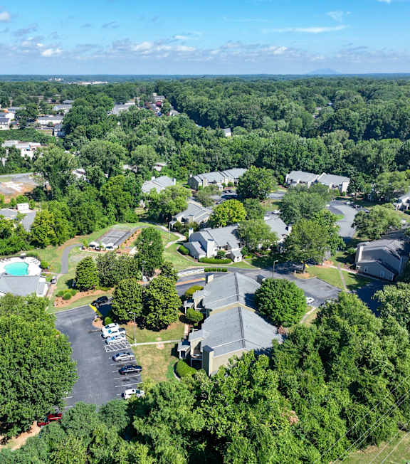 A bird's eye view of a residential Legacy at Ardmore's apartment community in Winston-Salem NC with trees and a view of the sky.