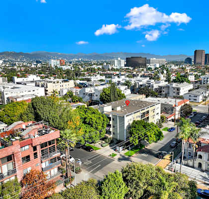 A cityscape with buildings, trees, and a clear sky at Wooster Encore Apartments, Los Angeles, California