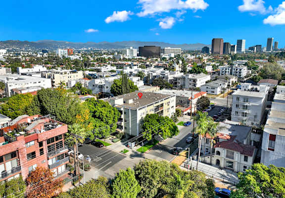 A cityscape with buildings, trees, and a clear sky at Wooster Encore Apartments, Los Angeles, California