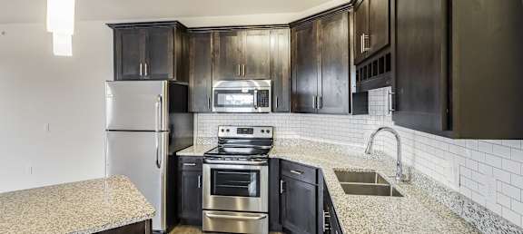 a kitchen with stainless-steel appliances and marble countertops