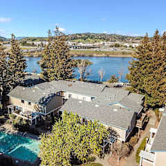 A large house with a pool in the foreground and a lake in the background. at Redwood Landing Apartments, California