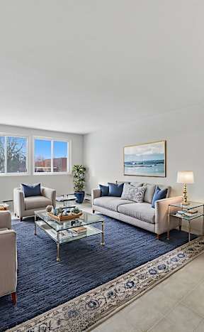 A living room with a couch, chairs, and a coffee table.