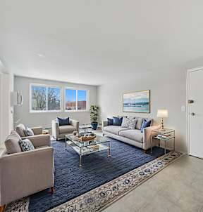 A living room with a couch, chairs, and a coffee table.