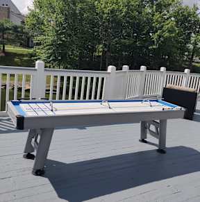 A table tennis table on a deck.