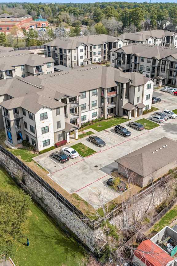 Apartment complex with a parking lot in front.
