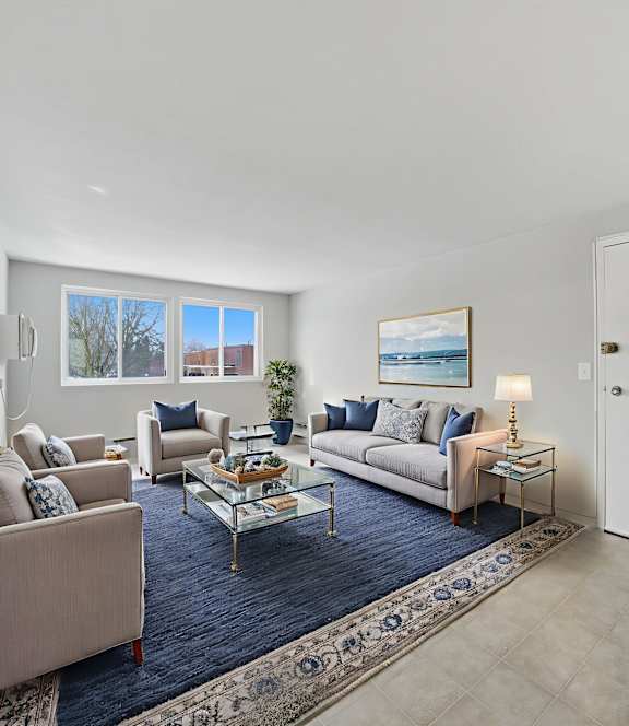 A living room with a couch, chairs, and a coffee table.