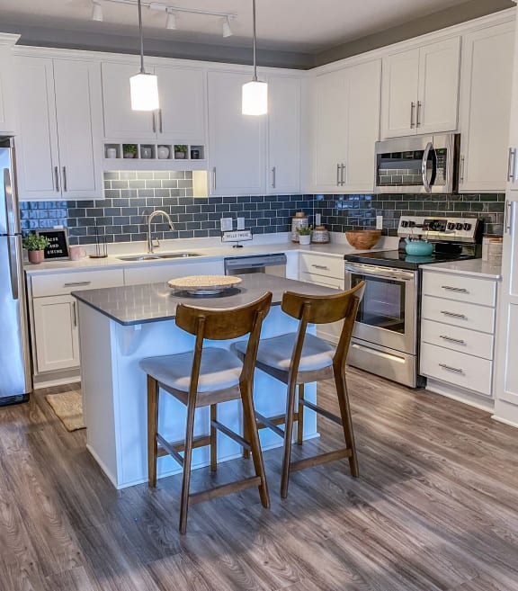 a kitchen with stainless steel appliances and white cabinets  at Timber Ridge, Forest Lake, 55025