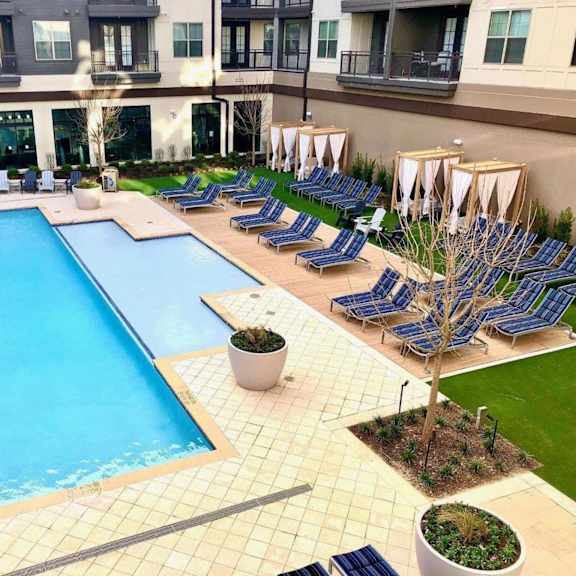a large swimming pool with lounge chairs around it