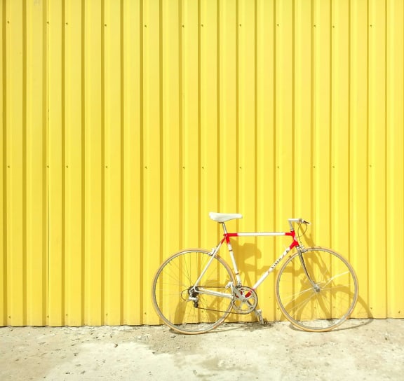 a bike parked in front of a yellow wall