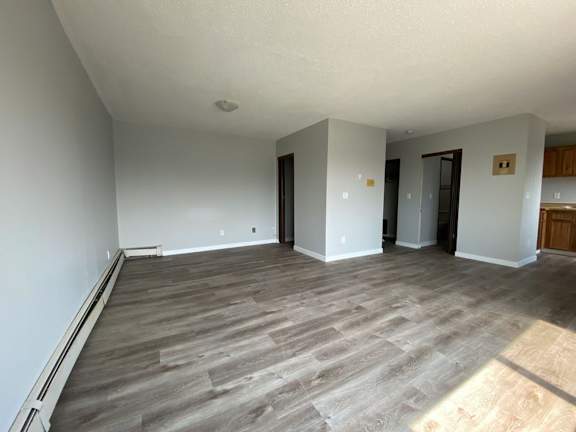 A room with wooden flooring and white walls.