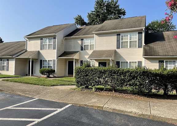 Apartment building with a parking lot in front.