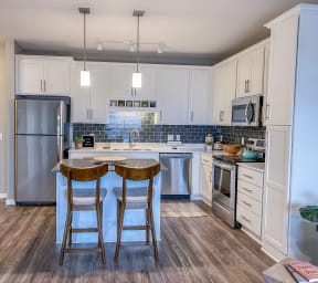 a kitchen with an island and stainless steel appliances  at Timber Ridge, Forest Lake, MN, 55025
