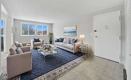 A living room with a couch, chairs, and a coffee table.
